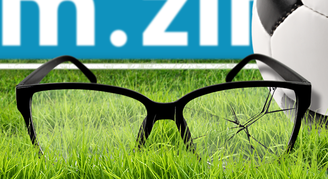 Kapotte bril met een voetbal op de achtergrond