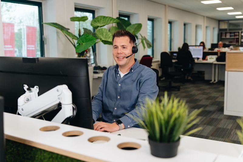 Klantadviseur achter bureau met headset