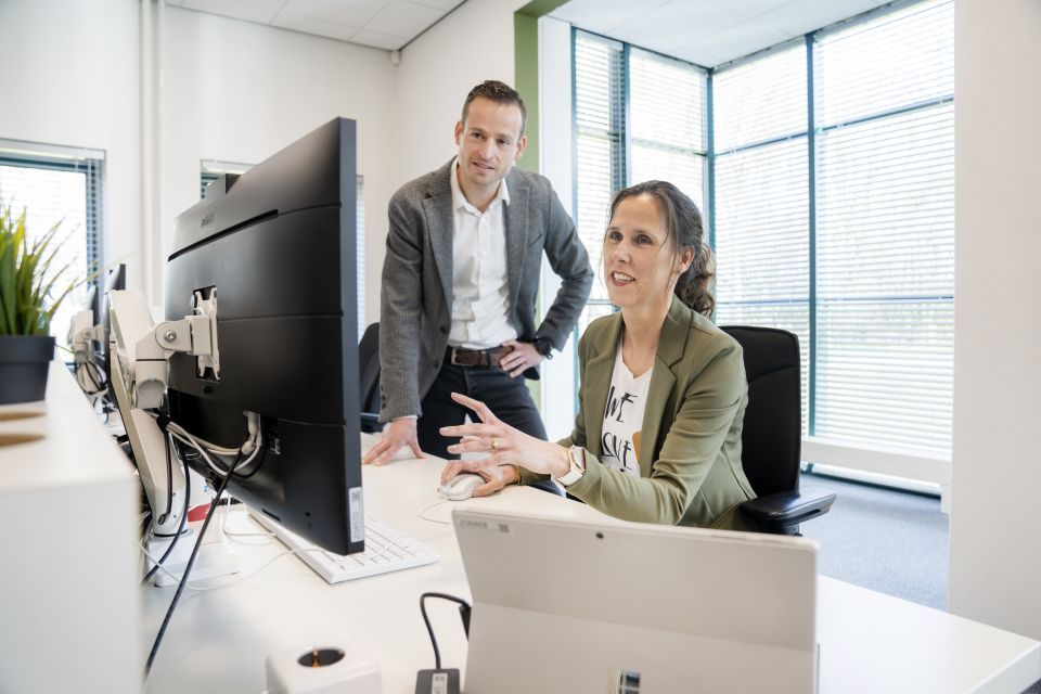 Mannelijke en vrouwelijke medewerker achter bureau