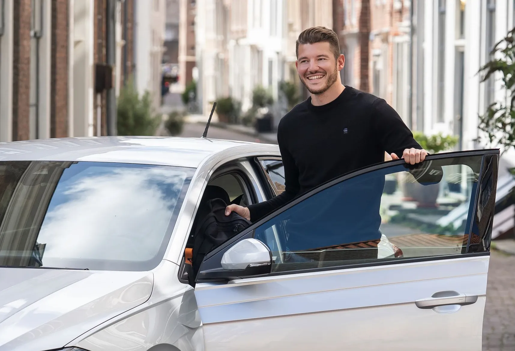 Man bij auto met open portier