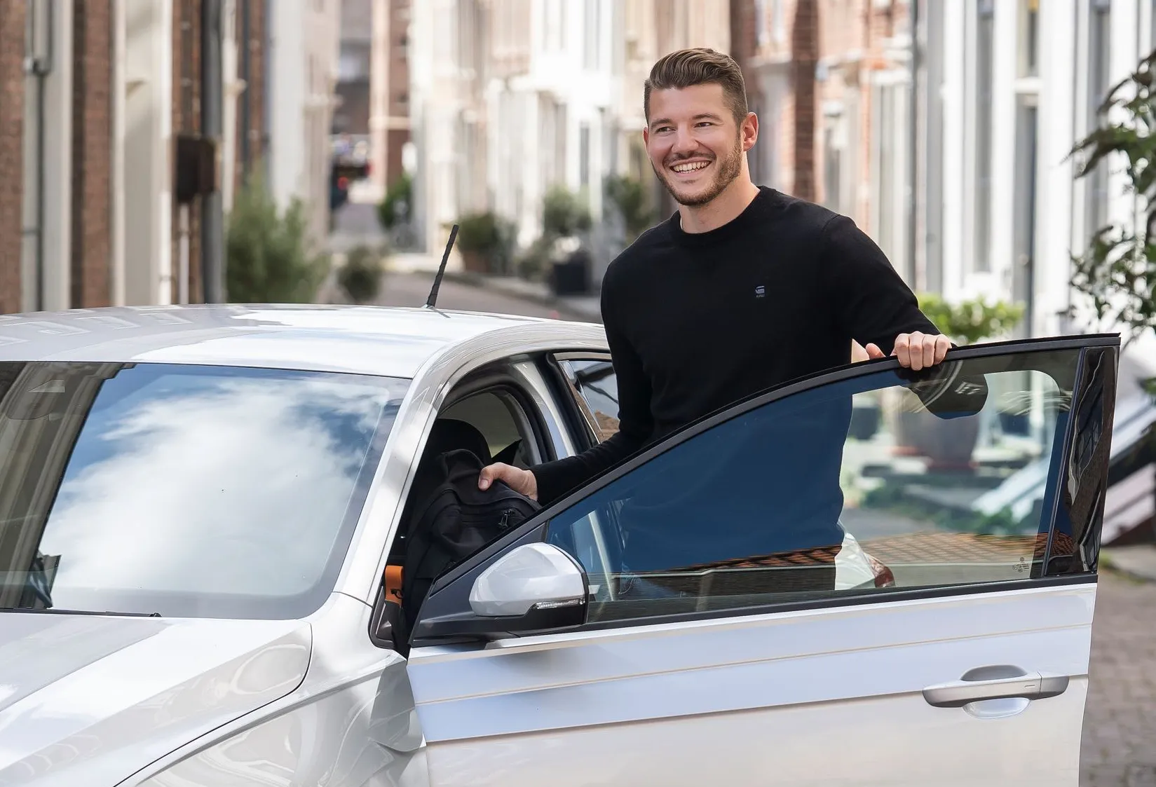 Man bij auto met open portier
